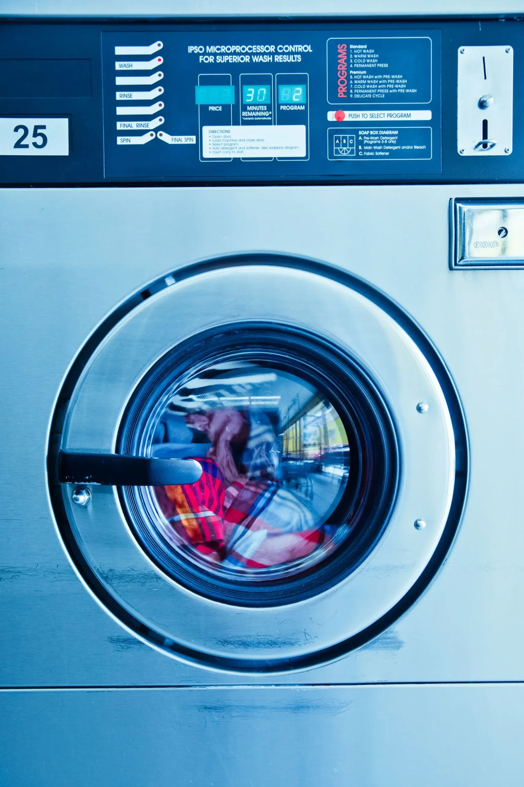 Professional laundry worker operating a commercial washing machine in Doha